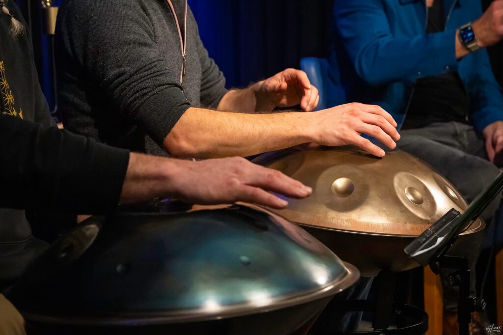 Hände spielen auf zwei Handpans.